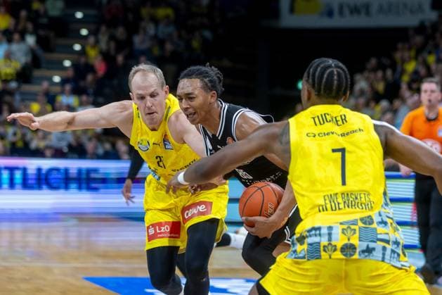 Oldenburg, Niedersachsen, DEU, 22.11.2025, Austin Crowley (Mitte, BMA365 Bamberg Baskets), Seth Hinrichs (links, EWE Baskets Oldenburg) und Dakarai Tucker (rechts, EWE Baskets Oldenburg). EWE Baskets Oldenburg vs. BMA365 Bamberg Baskets. 1. Basketball-Bundesliga Saison 2025 2026, 8. Spieltag, Grosse EWE Arena. EWE Baskets Oldenburg vs. BMA365 Bamberg Baskets
