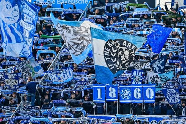 Fans des TSV 1860 Muenchen zeigen ihre Schals, schwenken Fahnen und machen Stimmung, Fans, Publikum, Zuschauer, Stimmung, Atmosphaere, Stadion, 23.11.2025, München (Deutschland), Fussball, 3. Liga, TSV 1860 München - 1. FC Saarbrücken, DFB DFL REGULATIONS PROHIBIT ANY USE OF PHOTOGRAPHS AS IMAGE SEQUENCES AND OR QUASI-VIDEO.