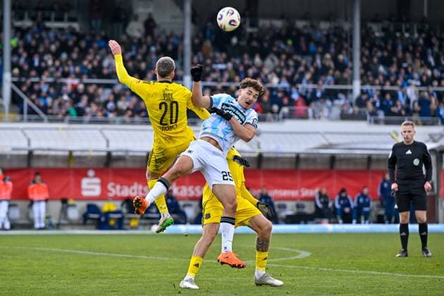 v.li.: Florian Pick (Saarbruecken, 20) Sean Dulic (TSV 1860, 25) Patrick Schmidt (Saarbruecken, 39) im Zweikampf, Duell, duel, tackle, Dynamik, Action, Aktion, Felix Weller (Schiedsrichter, Referee) beobachtet die Szene, 23.11.2025, München (Deutschland), Fussball, 3. Liga, TSV 1860 München - 1. FC Saarbrücken, DFB DFL REGULATIONS PROHIBIT ANY USE OF PHOTOGRAPHS AS IMAGE SEQUENCES AND OR QUASI-VIDEO.