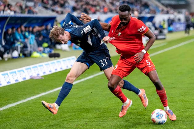 v.li.: Max Moerstedt (Hoffenheim, 33), Chrislain Matsima (FCA, 5), Zweikampf, Spielszene, Duell, duel, tackle, tackling, Dynamik, Action, Aktion, 29.11.2025, Sinsheim (Deutschland), Fussball, Bundesliga, TSG 1899 Hoffenheim - FC Augsburg, DFB DFL REGULATIONS PROHIBIT ANY USE OF PHOTOGRAPHS AS IMAGE SEQUENCES AND OR QUASI-VIDEO.