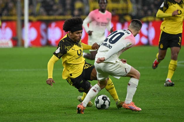 02.12.2025, xjhx, Fussball DFB Pokal Achtelfinale, Borussia Dortmund - Bayer 04 Leverkusen emspor, v.l. Karim David Adeyemi (Dortmund, 27), Alejandro Grimaldo (Leverkusen, 20) Zweikampf, Duell, Kampf, tackle (DFL DFB REGULATIONS PROHIBIT ANY USE OF PHOTOGRAPHS as IMAGE SEQUENCES and or QUASI-VIDEO) Dortmund