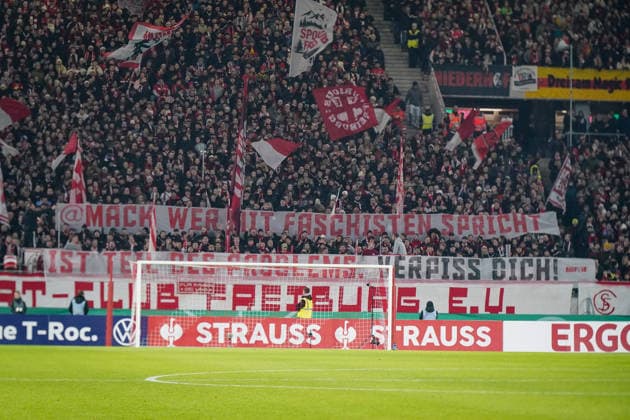 Deutschland: Fussball DFB-Pokal 2025 26, Achtelfinale - SC Freiburg vs SV Darmstadt 98 - Europa-Park-Stadion (Freiburg): SCF-Fankurve, großes Protestbanner gegen aktuelle Mack-Äußerungen im AfD-Kontext, politische Botschaft, gesellschaftliche Debatte, Fanaktivismus, kritische Fanszene, rote Fahnen, volle Kurve, DFB-Pokal, Emotionen, Sicherheit, Fußballkultur, Sportevent. Freiburg im Breisgau Baden-Württemberg Deutschland Copyright: xJOERANxSTEINSIEKx