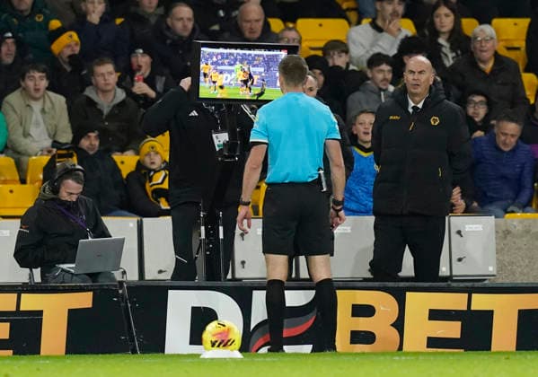 Wolverhampton, England, 8th December 2025. Referee Michael Salisbury watches the VAR playback before awarding Manchester United, ManU a penalty during the Wolverhampton Wanderers vs Manchester United Premier League match at Molineux, Wolverhampton. Picture credit should read: Andrew Yates Sportimage EDITORIAL USE ONLY. No use with unauthorised audio, video, data, fixture lists, club league logos or live services. Online in-match use limited to 120 images, no video emulation. No use in betting, games or single club league player publications. SPI_083_AY_Wolves_Man_Utd SPI-4356-0085