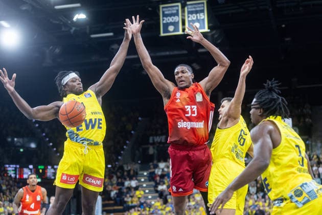 Oldenburg, Niedersachsen, DEU, 14.12.2025, David McCormack (Mitte, FC Bayern München Basketball), Brian Fobbs (links, EWE Baskets Oldenburg), Filip Stanic (2. v. rechts, EWE Baskets Oldenburg), Christopher Clemons (rechts, EWE Baskets Oldenburg) EWE Baskets Oldenburg vs. FC Bayern München Basketball. 1. Basketball-Bundesliga Saison 2025 2026, 10. Spieltag, Grosse EWE Arena. EWE Baskets Oldenburg vs. FC Bayern München Basketball