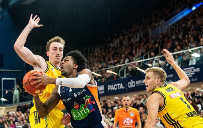 26.12.2025, Basketball, Herren, easy credit BBL, easy credit Bundesliga, BBL, Bundesliga, 12. Spieltag, Rostock Seawolves - ALBA Berlin Moses Wood (Alba Berlin, li.) und Sam Griesel (Alba Berlin, re.) gegen Jordan Bowden (Rostock Seawolves, Mitte) Rostock Stadthalle Mecklenburg-Vorpommern Deutschland