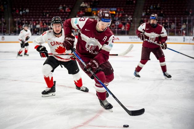 December 27, 2025, Minneapolis, Mn, Canada: Latvia s Alberts Smits (23) defends against Canada s Cole Reschny (21) during first period IIHF World Junior Championship hockey action, in Minneapolis, Minn., on Saturday, Dec. 27, 2025. Canada News - December 27, 2025 - ZUMAc35_ 20251227_zaf_c35_071 Copyright: xChristopherxKatsarovx
