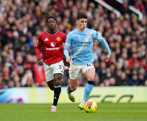 Manchester, England, 17th January 2026. Phil Foden of Manchester City (r) moves away from Kobbie Mainoo of Manchester United, ManU (l) during the Manchester United vs Manchester City Premier League match at Old Trafford, Manchester. Picture credit should read: Andrew Yates Sportimage EDITORIAL USE ONLY. No use with unauthorised audio, video, data, fixture lists, club league logos or live services. Online in-match use limited to 120 images, no video emulation. No use in betting, games or single club league player publications. SPI_062_AY_ManUtd_ManCity SPI-4456-0061