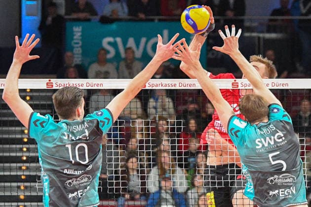Joshua Glasbergen (Warnemünde, 12) schmettert den Ball gegen den Block von Petteri Samuli Tyynismaa (Powervolleys Düren, 10) und Sjors Tijhuis (Powervolleys Düren, 5), Aktion, Action, Spielszene, 24.01.2026, Düren (Deutschland), Volleyball, 1. Bundesliga Männer, SWD Powervolleys Düren - Warnemünde