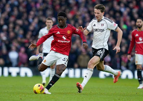 Manchester, England, 1st February 2026. Kobbie Mainoo of Manchester United, ManU (L) is challenged by Sander Berge of Fulham during the Manchester United vs Fulham Premier League match at Old Trafford, Manchester. Picture credit should read: Andrew Yates Sportimage EDITORIAL USE ONLY. No use with unauthorised audio, video, data, fixture lists, club league logos or live services. Online in-match use limited to 120 images, no video emulation. No use in betting, games or single club league player publications. SPI_058_AY_MAN_UTD_FULHAM SPI-4502-0057