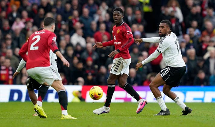 Manchester, England, 1st February 2026. Kobbie Mainoo of Manchester United, ManU (C) is challenged by Alex Iwobi of Fulham during the Manchester United vs Fulham Premier League match at Old Trafford, Manchester. Picture credit should read: Andrew Yates Sportimage EDITORIAL USE ONLY. No use with unauthorised audio, video, data, fixture lists, club league logos or live services. Online in-match use limited to 120 images, no video emulation. No use in betting, games or single club league player publications. SPI_060_AY_MAN_UTD_FULHAM SPI-4502-0059