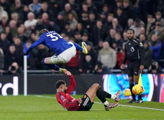 Liverpool, England, 23rd February 2026. James Garner of Everton tackled by Matheus Cunha of Manchester United, ManU during the Everton vs Manchester United Premier League match at Hill Dickinson Stadium, Liverpool. Picture credit should read: Andrew Yates Sportimage EDITORIAL USE ONLY. No use with unauthorised audio, video, data, fixture lists, club league logos or live services. Online in-match use limited to 120 images, no video emulation. No use in betting, games or single club league player publications. SPI_029_AY_Everton_Man_Utd SPI-4547-0029