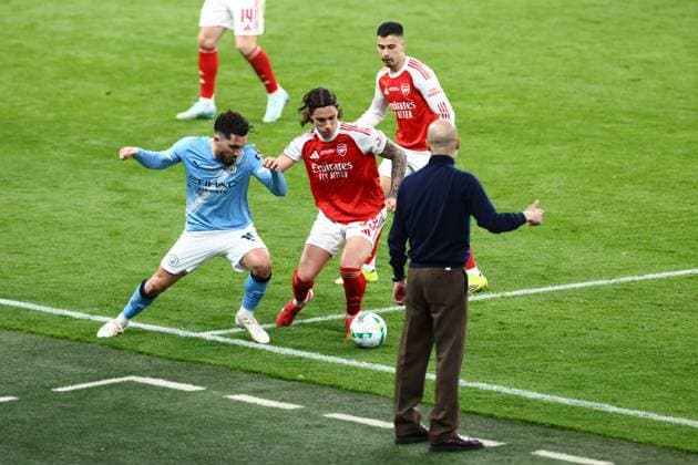 Rayan Cherki of Manchester City and Riccardo Calafiori of Arsenal battle in front of Pep Guardiola Arsenal v Manchester City, EFL Carabao Cup, Final, Football, Wembley Stadium, London, UK - 22 Mar 2026London Wembley Stadium United Kingdom EDITORIAL USE ONLY No use with unauthorised audio, video, data, fixture lists, club league logos or live services. Online in-match use limited to 120 images, no video emulation. No use in betting, games or single club league player publications. Copyright: xJamesxMarsh Shutterstockx 16783338ox