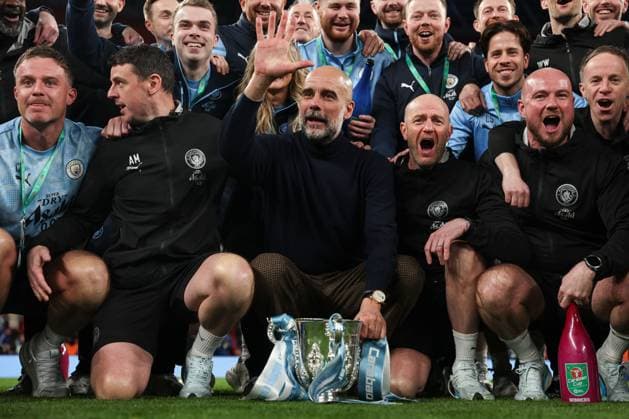 Manchester City manager Pep Guardiola gestures five times as he holds the 2026 Carabao Cup trophy in front of the winners board Arsenal v Manchester City, EFL Carabao Cup, Final, Football, Wembley Stadium, London, UK - 22 Mar 2026London Wembley Stadium United Kingdom EDITORIAL USE ONLY No use with unauthorised audio, video, data, fixture lists, club league logos or live services. Online in-match use limited to 120 images, no video emulation. No use in betting, games or single club league player publications. Copyright: xKieranxMcManus Shutterstockx 16783332na