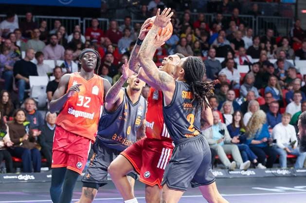 Xavier Rathan-Mayes 4 (FC Bayern Muenchen Basketball) wird von Nike Sibande 2 (Niners Chemnitz) geblockt, Wenyen Gabriel 32 (FC Bayern Muenchen Basketball), links, schaut zu, FC Bayern Muenchen Basketball vs. Niners Chemnitz, easyCredit BBL, Basketball, Bundesliga, Maenner, Hauptrunde, 12. April 2026 Muenchen Bayern Deutschland