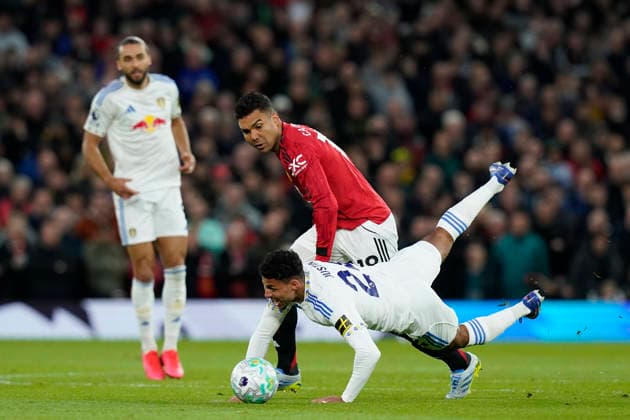 Manchester, England, 13th April 2026. Casemiro of Manchester United, ManU and James Justin of Leeds United challenge for the ball during the Manchester United vs Leeds United Premier League match at Old Trafford, Manchester. Picture credit should read: Andrew Yates Sportimage EDITORIAL USE ONLY. No use with unauthorised audio, video, data, fixture lists, club league logos or live services. Online in-match use limited to 120 images, no video emulation. No use in betting, games or single club league player publications. SPI_029_AY_Man_Utd_Leeds SPI-4684-0029