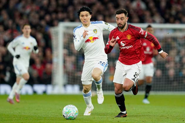 Manchester, England, 13th April 2026. Bruno Fernandes of Manchester United, ManU with the ball ahead of Ao Tanaka of Leeds United during the Manchester United vs Leeds United Premier League match at Old Trafford, Manchester. Picture credit should read: Andrew Yates Sportimage EDITORIAL USE ONLY. No use with unauthorised audio, video, data, fixture lists, club league logos or live services. Online in-match use limited to 120 images, no video emulation. No use in betting, games or single club league player publications. SPI_030_AY_Man_Utd_Leeds SPI-4684-0030