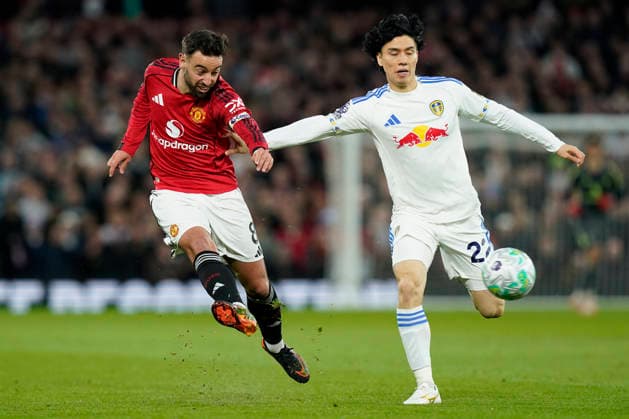 Manchester, England, 13th April 2026. Bruno Fernandes of Manchester United, ManU and Ao Tanaka of Leeds United challenge for the ball during the Manchester United vs Leeds United Premier League match at Old Trafford, Manchester. Picture credit should read: Andrew Yates Sportimage EDITORIAL USE ONLY. No use with unauthorised audio, video, data, fixture lists, club league logos or live services. Online in-match use limited to 120 images, no video emulation. No use in betting, games or single club league player publications. SPI_031_AY_Man_Utd_Leeds SPI-4684-0031