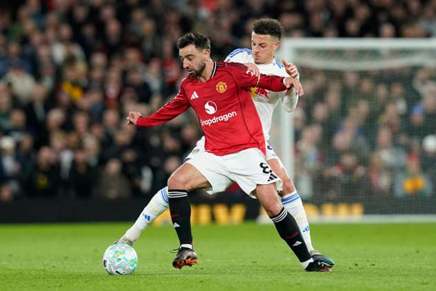 Manchester, England, 13th April 2026. Bruno Fernandes of Manchester United, ManU and Ethan Ampadu of Leeds United challenge for the ball during the Manchester United vs Leeds United Premier League match at Old Trafford, Manchester. Picture credit should read: Andrew Yates Sportimage EDITORIAL USE ONLY. No use with unauthorised audio, video, data, fixture lists, club league logos or live services. Online in-match use limited to 120 images, no video emulation. No use in betting, games or single club league player publications. SPI_041_AY_Man_Utd_Leeds SPI-4684-0041