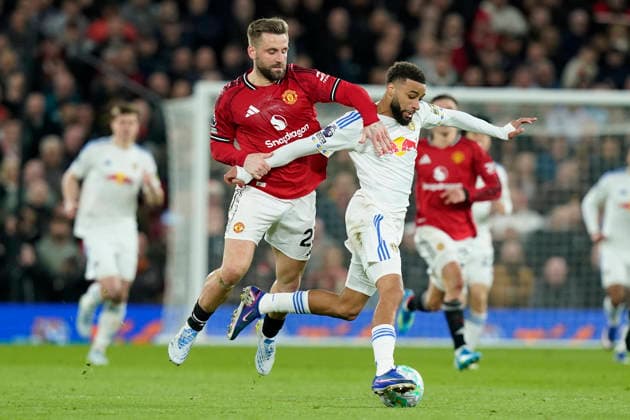 Manchester, England, 13th April 2026. Jayden Bogle of Leeds United is fouled by Luke Shaw of Manchester United, ManU who receives a yellow card during the Manchester United vs Leeds United Premier League match at Old Trafford, Manchester. Picture credit should read: Andrew Yates Sportimage EDITORIAL USE ONLY. No use with unauthorised audio, video, data, fixture lists, club league logos or live services. Online in-match use limited to 120 images, no video emulation. No use in betting, games or single club league player publications. SPI_053_AY_Man_Utd_Leeds SPI-4684-0053