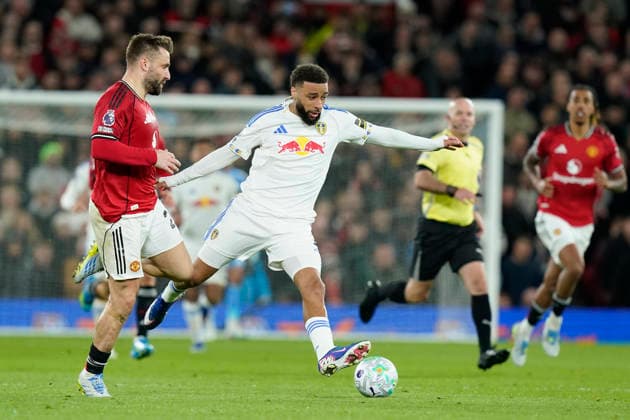 Manchester, England, 13th April 2026. Jayden Bogle of Leeds United is fouled by Luke Shaw of Manchester United, ManU who receives a yellow card during the Manchester United vs Leeds United Premier League match at Old Trafford, Manchester. Picture credit should read: Andrew Yates Sportimage EDITORIAL USE ONLY. No use with unauthorised audio, video, data, fixture lists, club league logos or live services. Online in-match use limited to 120 images, no video emulation. No use in betting, games or single club league player publications. SPI_054_AY_Man_Utd_Leeds SPI-4684-0054