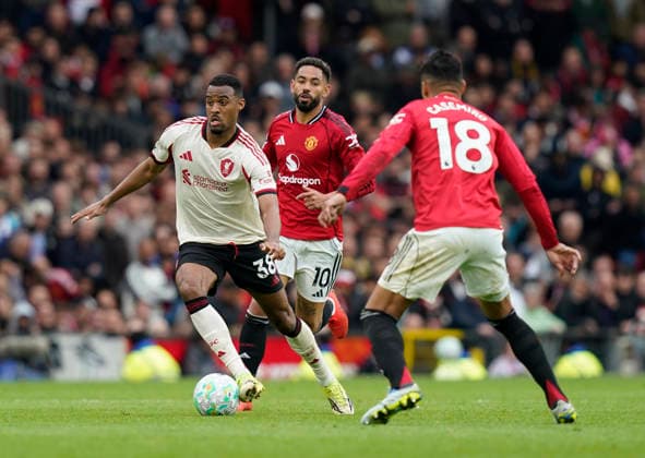 Manchester, England, 3rd May 2026. Ryan Gravenberch of Liverpool escapes Matheus Cunha of Manchester United, ManU during the Manchester United vs Liverpool Premier League match at Old Trafford, Manchester. Picture credit should read: Andrew Yates Sportimage EDITORIAL USE ONLY. No use with unauthorised audio, video, data, fixture lists, club league logos or live services. Online in-match use limited to 120 images, no video emulation. No use in betting, games or single club league player publications. SPI_093_AY_MAN_UTD_LIVERPOOL SPI-4776-0092