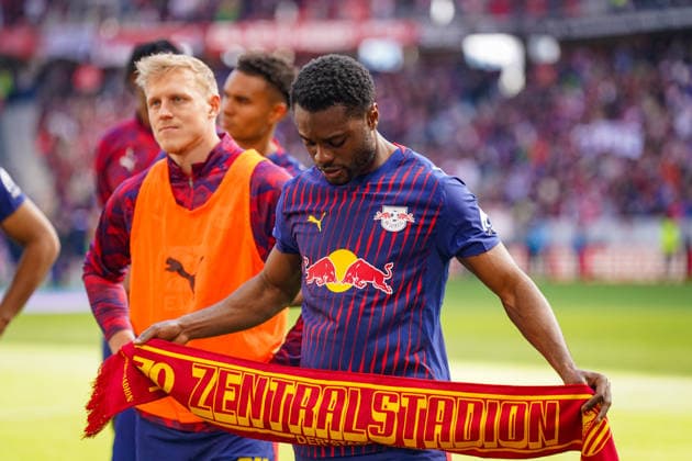 Deutschland: Fussball Bundesliga 2025 - 2026, 34. Spieltag - SC Freiburg vs RB Leipzig - Europa-Park-Stadion (Freiburg): Ridle Baku (RB Leipzig, 17) hält nach dem Bundesliga-Spiel einen Schal mit der Aufschrift 70 Jahre Zentralstadion der Stadt Leipzig in die Höhe. Spieler von RB Leipzig vor dem Gästeblock im Europa-Park-Stadion, Auswärtsmannschaft, Fußballfans, Bundesliga, Vereinsgeschichte, Leipziger Fußballtradition, Stadionatmosphäre, Sportevent, Deutschland. Copyright: xJOERANxSTEINSIEKx
