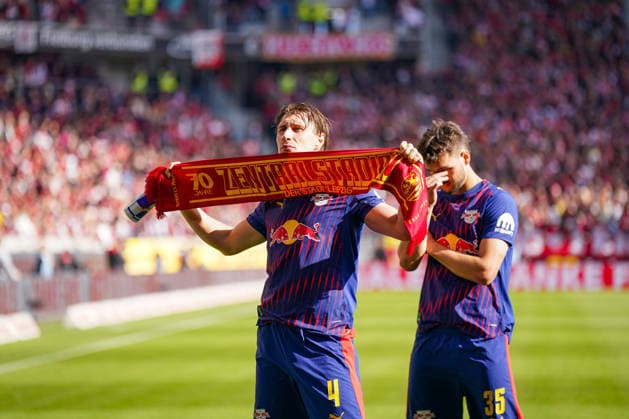 Deutschland: Fussball Bundesliga 2025 - 2026, 34. Spieltag - SC Freiburg vs RB Leipzig - Europa-Park-Stadion (Freiburg): Willi Orban Willi Orban Willi Orban (RB Leipzig, 4) hält nach dem Bundesliga-Spiel einen Schal mit der Aufschrift 70 Jahre Zentralstadion der Stadt Leipzig in die Höhe. Spieler von RB Leipzig vor dem Gästeblock im Europa-Park-Stadion, Auswärtsmannschaft, Fußballfans, Bundesliga, Vereinsgeschichte, Leipziger Fußballtradition, Stadionatmosphäre, Sportevent, Deutschland. Copyright: xJOERANxSTEINSIEKx