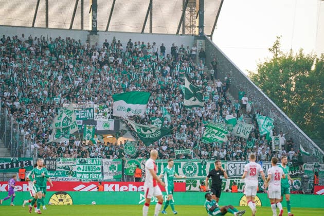 Deutschland: Fussball 2. Bundesliga Relegation 2025 - 2026 - Rot Weiss Essen vs SpVgg Greuther-Fürth - Stadion an der Hafenstraße (Essen): Gästefans der SpVgg Greuther-Fürth unterstützen ihre Mannschaft im ausverkauften Gästeblock mit zahlreichen grün-weißen Fahnen und Bannern. Aktive Fanszene und Ultras sorgen während des Relegationsspiels für Stimmung im Stadion an der Hafenstraße. Fußballfans, Supporters, Kleeblatt, Auswärtsfans, Gästeblock, Fankultur, Choreografie, Aufstiegskampf, 2. Bundesliga, Matchday, Stadionatmosphäre, Fußballtradition, Sportevent, Ruhrgebiet, Nordrhein-Westfalen, STEINSIEK.CH Copyright: xJOERANxSTEINSIEKx