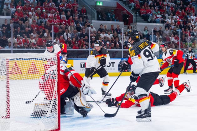 ZURICH, SWITZERLAND - MAY 23: Leon Gawanke (Germany, 9) and Frederick Tiffels (Germany, 95) trying to score against Atte Tolvanen (Austria, 35) during the Preliminary Round - Group A Match 41 between Austria and Germany at the IIHF Ice hockey, Eishockey World Championship, WM, Weltmeisterschaft 2026, Swiss Life Arena on May 23, 2026 in Zurich, Switzerland. Zurich Switzerland Copyright: xTimoxSteinx