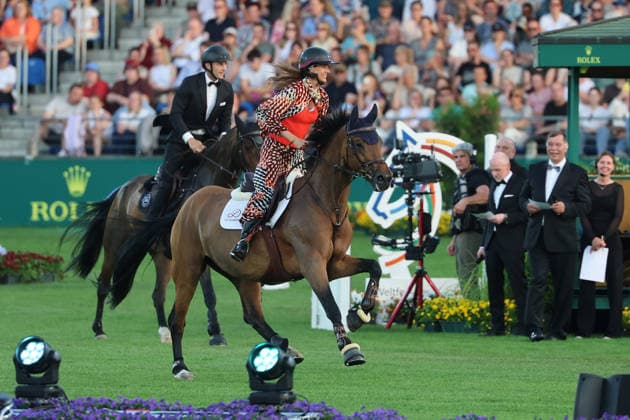 Richard Vogel und Luciana Diniz im Tempo gemeinsam in Bond-Stunt-Feeling über die Hindernisse, Konzert Pferd & Sinfonie, Rahmenprogramm, Motto des Abends: James Bond, Weltfest des Pferdesports, World Equestrian Festival, TSCHIO Aachen 2026, TSCHIO statt CHIO 2026, Aachener Soers, 22. bis 24. Mai 2026, Reitsport, 23.05.2026, Aachen Aachener Soers Deutschland