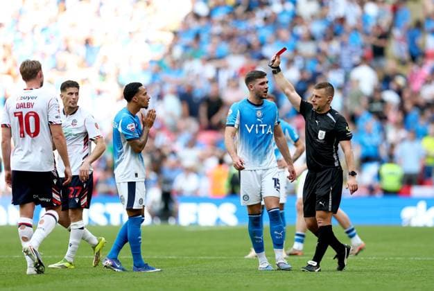 Josh Dacres-Cogley of Stockport County (left) is shown a red card by referee Josh Smith after a hair pull on Ibrahim Cissoko of Bolton Wanderers (not pictured) Bolton Wanderers v Stockport County, EFL Sky Bet League One, Play-Off Final, Football, Wembley Stadium, London, UK - 24 May 2026London Wembley Stadium United Kingdom EDITORIAL USE ONLY No use with unauthorised audio, video, data, fixture lists, club league logos or live services. Online in-match use limited to 120 images, no video emulation. No use in betting, games or single club league player publications. Copyright: xSimonxDael Shutterstockx 16889811fj