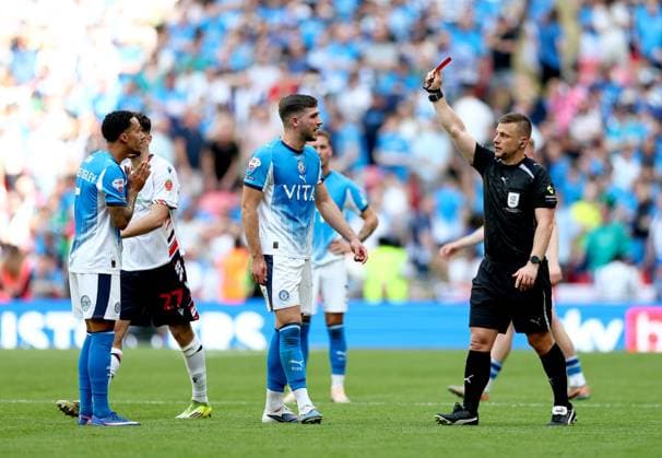 Josh Dacres-Cogley of Stockport County (left) is shown a red card by referee Josh Smith after a hair pull on Ibrahim Cissoko of Bolton Wanderers (not pictured) Bolton Wanderers v Stockport County, EFL Sky Bet League One, Play-Off Final, Football, Wembley Stadium, London, UK - 24 May 2026London Wembley Stadium United Kingdom EDITORIAL USE ONLY No use with unauthorised audio, video, data, fixture lists, club league logos or live services. Online in-match use limited to 120 images, no video emulation. No use in betting, games or single club league player publications. Copyright: xSimonxDael Shutterstockx 16889811fi