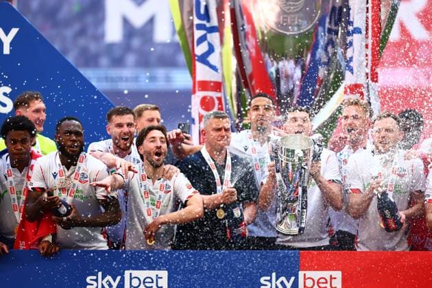 Bolton Wanderers manager Steven Schumacher of Bolton Wanderers with Eoin Toal , Josh Sheehan and the rest of the team celebrate with the League One Play off final trophy Bolton Wanderers v Stockport County, EFL Sky Bet League One, Play-Off Final, Football, Wembley Stadium, London, UK - 24 May 2026London Wembley Stadium United Kingdom EDITORIAL USE ONLY No use with unauthorised audio, video, data, fixture lists, club league logos or live services. Online in-match use limited to 120 images, no video emulation. No use in betting, games or single club league player publications. Copyright: xJoexToth Shutterstockx 16889806gy