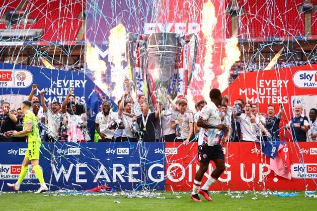 Bolton Wanderers manager Steven Schumacher of Bolton Wanderers with Eoin Toal , Josh Sheehan and the rest of the team celebrate with the League One Play off final trophy Bolton Wanderers v Stockport County, EFL Sky Bet League One, Play-Off Final, Football, Wembley Stadium, London, UK - 24 May 2026London Wembley Stadium United Kingdom EDITORIAL USE ONLY No use with unauthorised audio, video, data, fixture lists, club league logos or live services. Online in-match use limited to 120 images, no video emulation. No use in betting, games or single club league player publications. Copyright: xJamesxMarsh Shutterstockx 16889809da