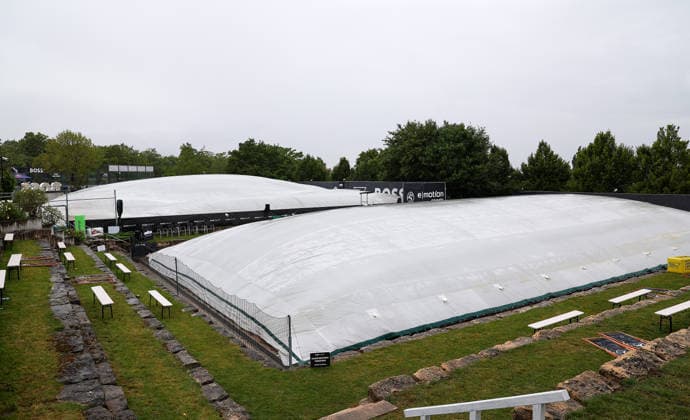 BAU 10.06.2026, Deutschland, Stuttgart, Tennis, BOSS Open 2026, Regen, Regenfeature, Feature, leere Ränge, Rasenabdeckung, Abdeckung, Übersicht, Mensch mit Regenschirm, Schirm