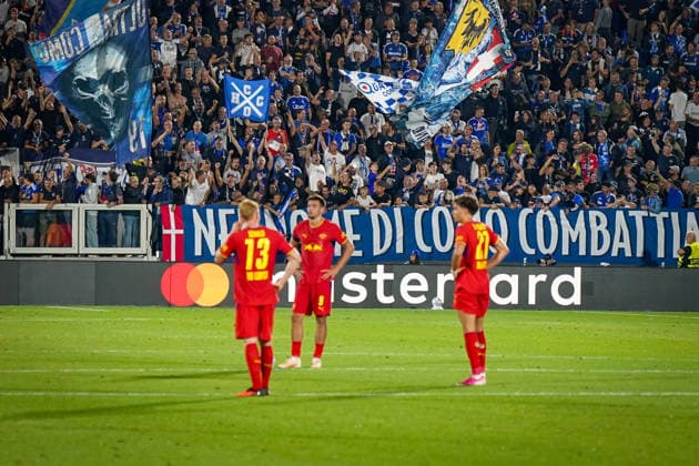 Italien: Fussball UEFA Champions League 2026 - 2027, 1. Spieltag - Como 1907 vs RB Leipzig - Giuseppe Sinigaglia (Como): Fans von Como 1907 feiern lautstark auf der Tribüne hinter Spielern von RB Leipzig. Große Fahnen und Transparent NEL NOME DI COMO COMBATTI. Fußball, Champions League, Como 1907, RB Leipzig, Fans, Zuschauer, Tribüne, Fanblock, Fankultur, Heimfans, Fahnen, Transparent, Spruchband, Stimmung, Emotionen, Mastercard, Werbung. Copyright: xJOERANxSTEINSIEKx