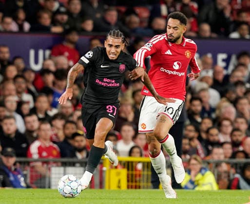 Manchester, England, 10th September 2026. Du Queiroz of Sabah FC attempts to get clear of Matheus Cunha of Manchester United, ManU during the Manchester United vs Sabah UEFA Champions League match at Old Trafford, Manchester. Picture credit should read: Andrew Yates Sportimage EDITORIAL USE ONLY. No use with unauthorised audio, video, data, fixture lists, club league logos or live services. Online in-match use limited to 120 images, no video emulation. No use in betting, games or single club league player publications. SPI_060_AY_Man_Utd_Sabah SPI-4989-0060