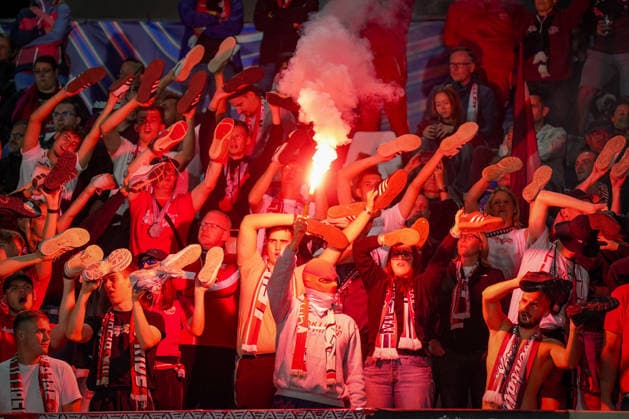 Italien: Fussball UEFA Champions League 2026 - 2027, 1. Spieltag - Como 1907 vs RB Leipzig - Giuseppe Sinigaglia (Como): Fans von RB Leipzig im Gästeblock halten bei einer Choreographie ihre Schuhe in die Höhe, während ein Fan Pyrotechnik Bengalo zündet. Fußball, Champions League, RB Leipzig, Auswärtsfans, Zuschauer, Fans, Ultras, Fankultur, Fanchoreo, Choreographie, Pyrotechnik, Bengalo, Rauch, Gästetribüne, Fanblock, Stimmung, Emotionen. Copyright: xJOERANxSTEINSIEKx