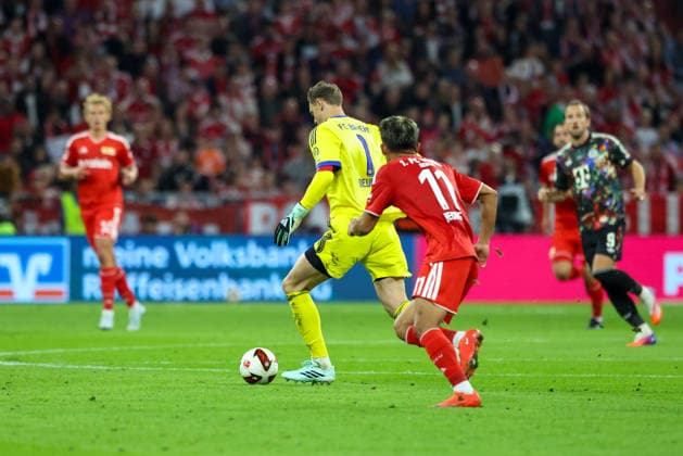 Manuel Neuer (FC Bayern Muenchen, 01) mit Ball nahe dem Mittelkreis an Woo-Yeong Jeong (1. FC Union Berlin, 11), GER, FC Bayern Muenchen vs. 1. FC Union Berlin, Fussball, Bundesliga, 4. Spieltag, Saison 2026 2027, 18.09.2026, DFL DFB REGULATIONS PROHIBIT ANY USE OF PHOTOGRAPHS as IMAGE SEQUENCES and or QUASI-VIDEO, GER, FC Bayern Muenchen vs. 1. FC Union Berlin, Fussball, Bundesliga, 4. Spieltag, Saison 2026 2027, 18.09.2026 Muenchen Copyright: xEibner-Pressefoto JennixMaulx EP_JML