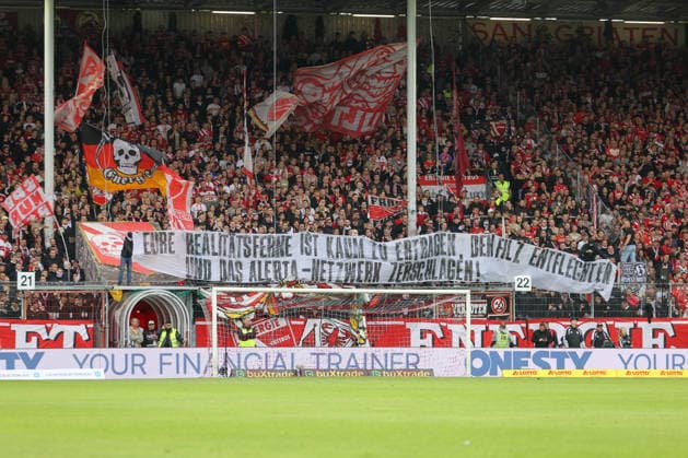 20.09.2026, xtgx, Fussball 2. Bundesliga, FC Energie Cottbus - FC St. Pauli, v.l. Symbolfoto, Symbolbild, Symbol Fans, Zuschauer, Publikum, Tribuene Spruchband Banner Eure Realitätsferne ist kaum zu ertragen, den Filz entflechten und das Alerta-Netzwerk zerschlagen! (DFL DFB REGULATIONS PROHIBIT ANY USE OF PHOTOGRAPHS as IMAGE SEQUENCES and or QUASI-VIDEO) Cottbus