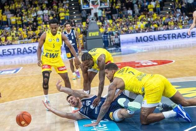 Oldenburg, Niedersachsen, DEU, 20.09.2026, Jure Planinic (unten, Syntainics MBC), Demajeo Wiggins (rechts, EWE Baskets Oldenburg), Nate Johnson (Mitte, EWE Baskets Oldenburg) und Jeremy Roach (links, EWE Baskets Oldenburg). EWE Baskets Oldenburg vs. Syntainics MBC. Basketball. 1. Basketball-Bundesliga Saison 2026 2027, 1. Spieltag, Grosse EWE Arena. EWE Baskets Oldenburg vs. Syntainics MBC Weißenfels