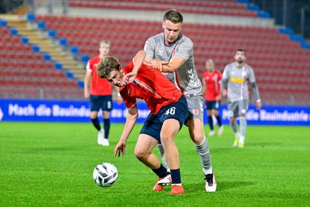v.li.: Marinus Spann (Unterhaching, 46) Erik Majetschak (Regensburg, 13) im Zweikampf, Duell, duel, tackle, Dynamik, Action, Aktion, 06.10.2026, Unterhaching (Deutschland), Fussball, BFV Verbandspokal, Viertelfinale, SpVgg Unterhaching - SSV Jahn Regensburg