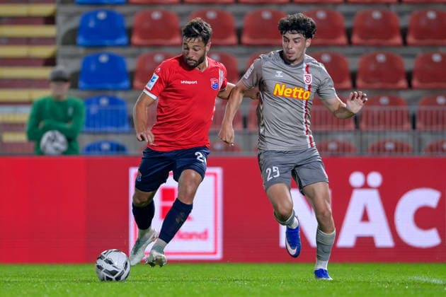 v.li.: Moritz Mueller (Unterhaching, 24) Nicolas Oliveira (Regensburg, 25) im Zweikampf, Duell, duel, tackle, Dynamik, Action, Aktion, 06.10.2026, Unterhaching (Deutschland), Fussball, BFV Verbandspokal, Viertelfinale, SpVgg Unterhaching - SSV Jahn Regensburg