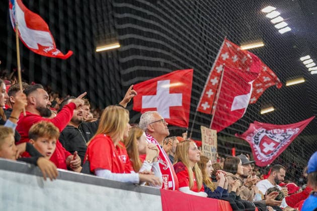 Fussball UEFA Nations League 2026 - 2027, 4. Spieltag - Schweiz vs Nordmazedonien - Thermoplan Arena (Luzern): Schweizer Fans schwenken National- und Fanflaggen auf der Tribüne beim UEFA-Nations-League-Spiel Schweiz gegen Nordmazedonien in Luzern. Schweizer Fans, Fans, Supporter, Fankultur, Fanblock, Zuschauer, Stimmung, Schweizer Fahne, Schweizer Flagge, Nationalflagge, Fanflaggen, Schweiz, Nordmazedonien, UEFA Nations League, Luzern, Thermoplan Arena, Länderspiel Copyright: xJOERANxSTEINSIEKx