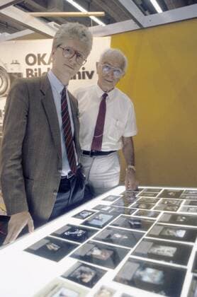 Prof. Dr. Bernhard Grzimek und sein Enkel Christian 10 86 rag Prof. Dr. Bernhard Grzimek mit seinem Enkel Christian während der Frankfurter Buchmesse 1986 Deutschland deutsch Deutscher Deutsche Männer Mann TV Fernsehen Fotografie Tier Tierfilm Tierfilmer Tierschutz Tierschützer Umweltschützer Umweltschutz grauhaarig Halbglatze leger Hemd Krawatte Brille Sakko Hemd seriös blond kurzhaarig Leuchttisch Leuchtkasten Dias Fotografien Fotos Positive Hochformat hoch halb stehend Frankfurt Main