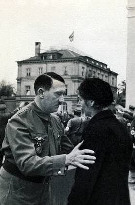 IMAGO History, Zweiter Weltkrieg: 1939 - 1945 Deutschland, Muenchen, 09.11.1934 Adolf Hitler ( 20. April 1889 in Braunau am Inn; 30. April 1945 in Berlin) war ein deutscher Politiker oesterreichischer Herkunft. Er war ab 29. Juli 1921 Vorsitzender der Nationalsozialistische Deutsche Arbeiterpartei (NSDAP), wurde am 30. Januar 1933 Reichskanzler und war von 1934 bis zu seinem Suizid 1945 unter der Bezeichnung ãFuehrer und ReichskanzlerÒ zugleich Regierungschef und Staatsoberhaupt des Deutschen Reiches, sowie ab 4. Februar 1938 Oberbefehlshaber der Wehrmacht. Foto: Adolf Hitler vor dem braunen Haus, bei der Wiederholung des historischen Marsches von 1923, wo der Hitler-Ludendorff-Putsch versuchte, am 09.November 1923 die Regierungsmacht an sich zu reißen, im Gespräch mit einer Parteigenossin Germany, Munich, 09.11.1934 Adolf Hitler (April 20, 1889 in Braunau am Inn, 30 April 1945 in Berlin) was a German politician of Austrian o