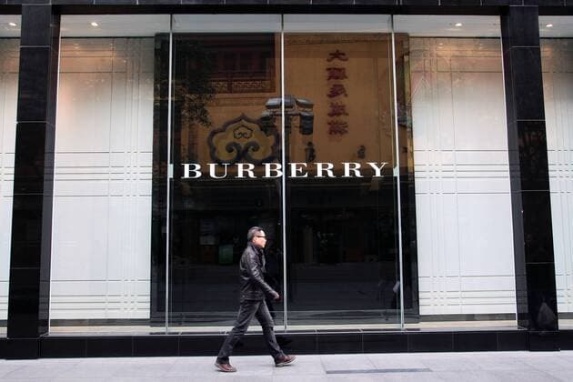 --File--A pedestrian walks past a Burberry boutique in Shanghai, China, 6 April 2012. Burberry has been awarded ¡ê63 million ($100 million) in damages after taking a network of Chinese counterfeiters to court. WWD report that the defendants, who ran websites such as yesburberryvision.com and buyburberry.com, were known to have sold at least 22 different product types all bearing imitations of the British heritage brands various trademarks, such as its iconic plaid check and equestrian knight logo. The resolution of the case, which was originally filed in January at Manhattan Federal Court, comes after months of waiting for the defendants to reply to the accusations and appear in court - neither of which was ever done. The domain names for all the infringing sites will now be transferred to Burberry, allowing the brand to cut off any associated internet providers, web designers, sponso 20120406_27124