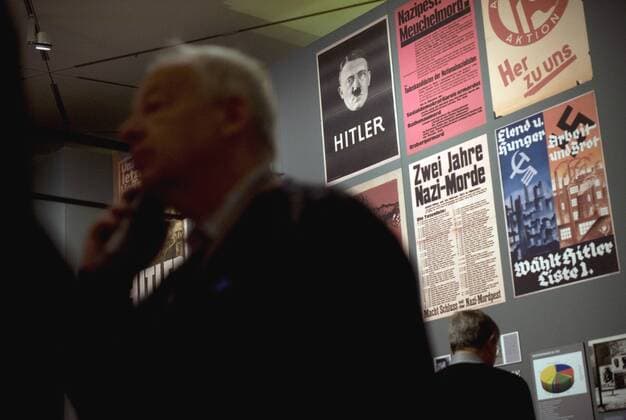Hitler exhibition, DHM Berlin DEU, Deutschland, Germany, Berlin, 15.10.2010 Besucher vor Plakaten zum Thema NSDAP und Adolf Hitler in der Ausstellung zum Thema Hitler und die Deutschen. Volksgemeinschaft und Verbrechen im Deutschen Historischen Museum DHM in Berlin. Kunst, Ausstellung, Museum, Kultur, Besucher, Kunstwerk, zeitgenoessisch, zeitgenoessische, symbolisch, SYMBOL, SYMBOLE, SYMBOLBILD, Symbolfoto, Diktator, Diktatur, Drittes Recih, Fuehrer, Fuehrerkult, Adolf Hitler, Mythos, Fuehrermythos, Gesellschaft, Inszenierung von Macht, Nationalsozialismus, nationalsozialistisch, NSDAP, Politik, deutscher Faschismus, faschistisch, feature, Europa, 2010, Person, Personen, Persoenlichkeit, Geschichte, deutsch, deutsche, Deutsche Historische Museum. Visiter near poster of Adolf Hitler at the exhibition Hitler and the Germans Nation and Crime, Hitler und die Deutschen Volksgemeinschaft und