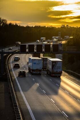 Autos und Lkw fahren auf der A2 bei Helmstedt (Niedersachsen) im Sonnenuntergang.