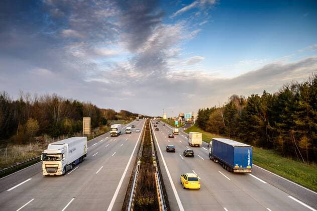 Autos und Lkw fahren auf der A2 bei Helmstedt (Niedersachsen) im Sonnenuntergang.